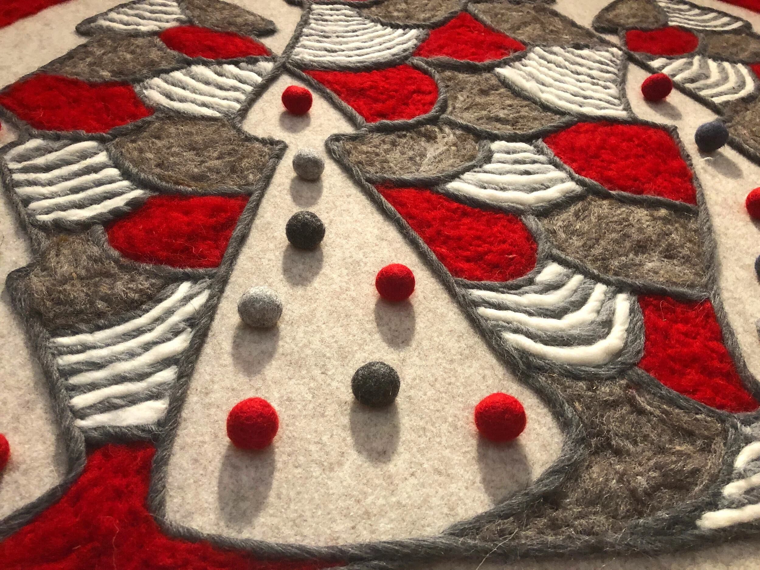 Trees beside a fireplace with felted painting above