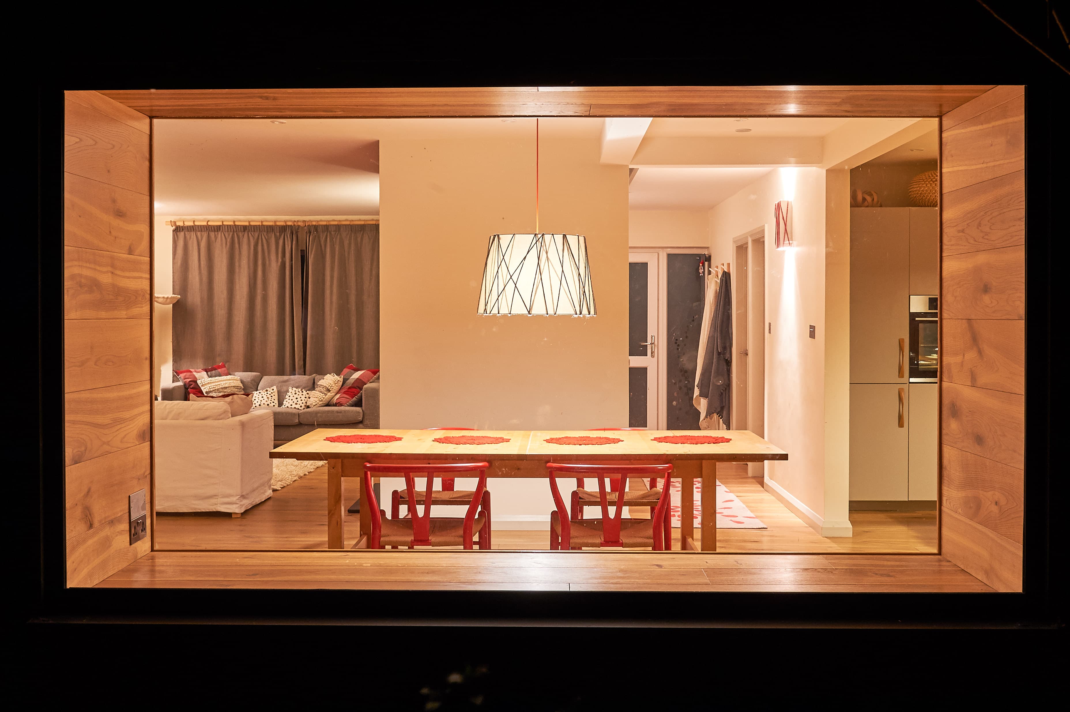 A cosy living room with red accents and warm wood tones