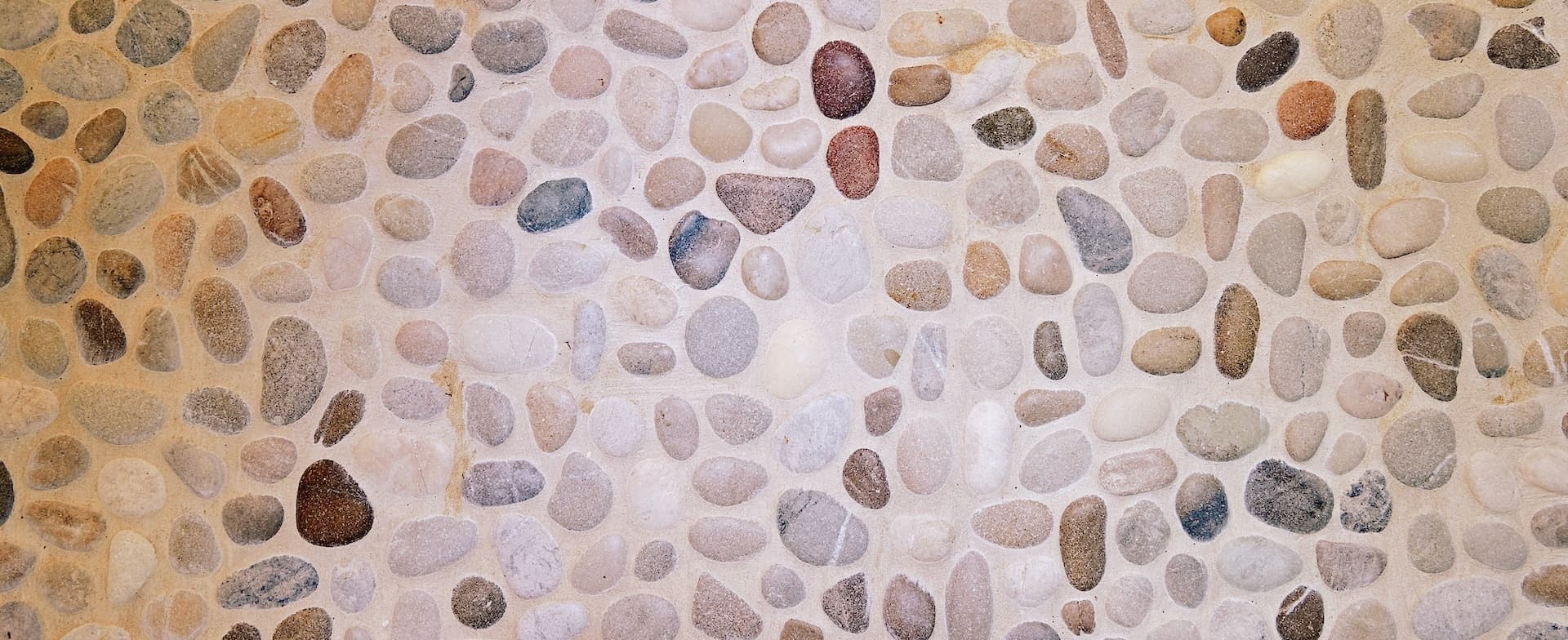 Pebble bathroom with stone wall and freestanding bath